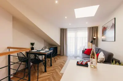 a living room with a table and a couch at Maisonette with terrace and view of Prague Castle in Prague