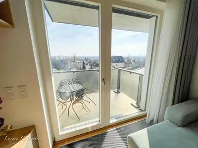 a room with a balcony with a view of the city at Incredible Luxury Apt with Garage and Tram Station in Prague