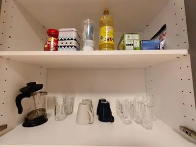 a kitchen shelf filled with glasses and utensils at My sweet place in Prague