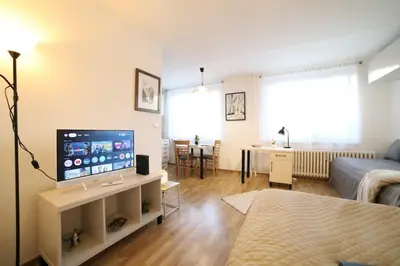 a living room with a television and a living room with a bed at Bright & Cozy Apartment with Netflix & Xbox! in Kladno
