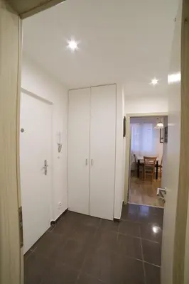 an empty room with white cabinets and a table at Bright & Cozy Apartment with Netflix & Xbox! in Kladno