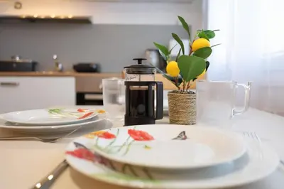 a table with two plates and a coffee maker at Bright & Cozy Apartment with Netflix & Xbox! in Kladno