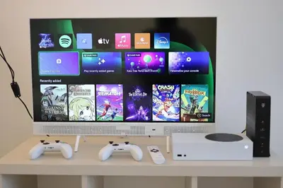 a computer monitor with two video game controllers on a table at Bright & Cozy Apartment with Netflix & Xbox! in Kladno