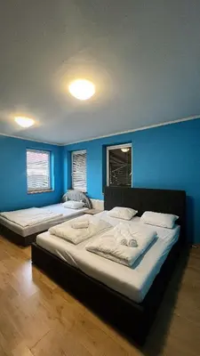 two beds in a room with blue walls at Sabina house in Vestec