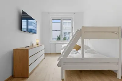 a white bedroom with a bunk bed and a dresser at Family apartment with kitchen near the subway in Prague
