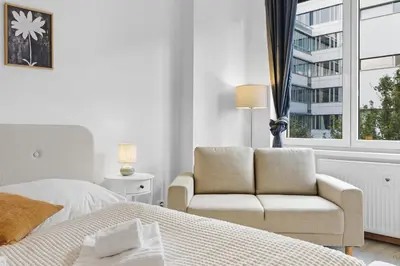 a bedroom with a bed and a chair and a window at Family apartment with kitchen near the subway in Prague