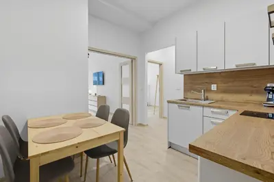 a kitchen and dining room with a wooden table and chairs at Family apartment with kitchen near the subway in Prague