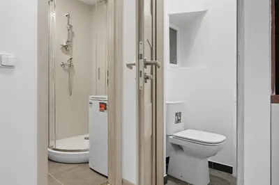 a white bathroom with a toilet and a shower at Family apartment with kitchen near the subway in Prague
