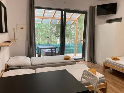 a living room with two beds and a large window at KuK Račice - 3 ložnice in Račice