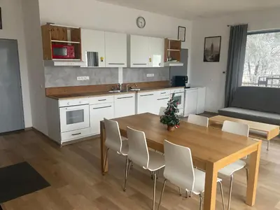 a kitchen and dining room with a wooden table and chairs at KuK Račice - 3 ložnice in Račice