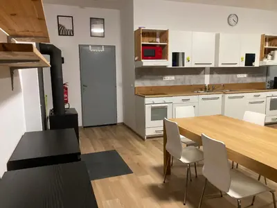 a kitchen with a wooden table and white cabinets at KuK Račice - 3 ložnice in Račice