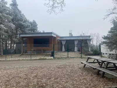a park with two picnic tables in front of a building at KuK Račice - 3 ložnice in Račice