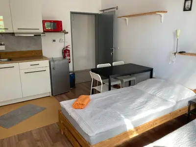 a room with a bed and a table and a kitchen at KuK Račice - 3 ložnice in Račice