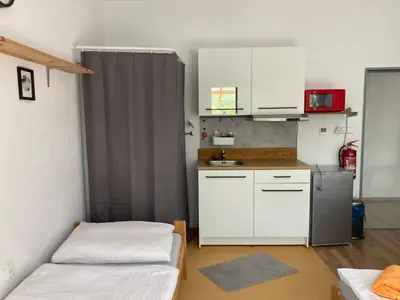 a small kitchen with two beds and a refrigerator at KuK Račice - 3 ložnice in Račice
