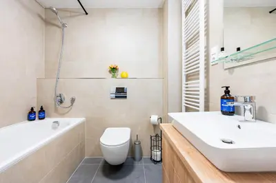 a bathroom with a sink and a toilet and a tub at Prague Days - One-Bedroom Apartment with Balcony, Garage & 250 Mbs WiFi in Prague