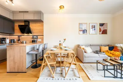 a kitchen and living room with a table and a couch at Prague Days - One-Bedroom Apartment with Balcony, Garage & 250 Mbs WiFi in Prague