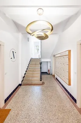 a hallway with stairs and a ceiling with a chandelier at Prague Days - One-Bedroom Apartment with Netflix in Holešovice in Prague