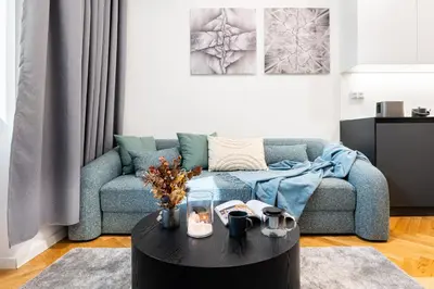 a living room with a blue couch and a table at Prague Days - One-Bedroom Apartment with Netflix in Holešovice in Prague