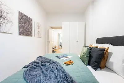 a bedroom with a bed with a blue blanket and pillows at Prague Days - One-Bedroom Apartment with Netflix in Holešovice in Prague