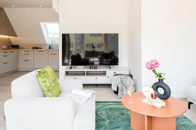a living room with a white couch and a table at Prague Days - Top Floor Apartments with Terrace & AC near Vyšehrad Castle in Prague