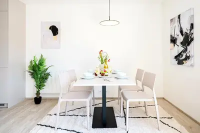 a white dining room with a white table and chairs at Prague Days - Top Floor Apartments with Terrace & AC near Vyšehrad Castle in Prague