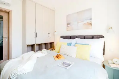 a bedroom with a large white bed with a book on it at Prague Days - Top Floor Apartments with Terrace & AC near Vyšehrad Castle in Prague
