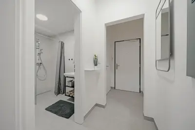 a white bathroom with a sink and a mirror at Mucha Residence - with free weekend parking in Prague