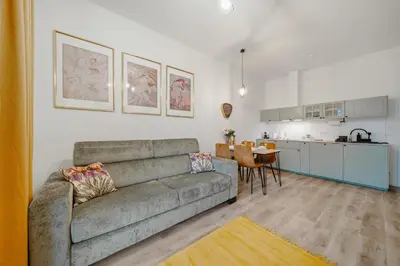a living room with a couch and a kitchen at Mucha Residence - with free weekend parking in Prague
