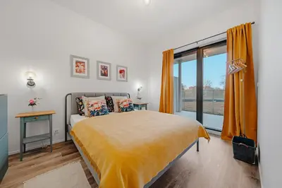 a bedroom with a bed and a large window at Mucha Residence - with free weekend parking in Prague