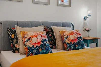 a bed with floral pillows on top of it at Mucha Residence - with free weekend parking in Prague