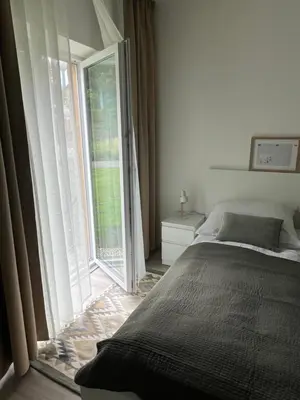 a bedroom with a bed and a large window at Prague Airport Apartment in Tuchoměřice
