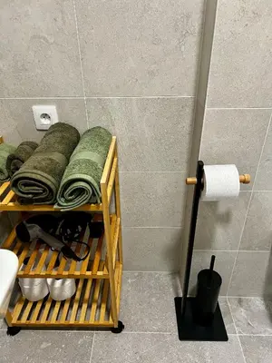 a shelf in a bathroom with towels and a toilet at Prague Airport Apartment in Tuchoměřice