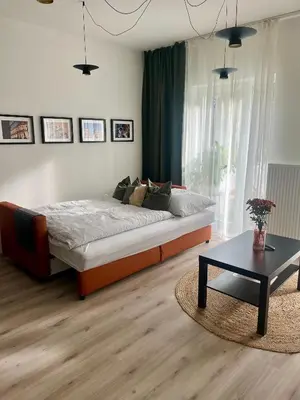 a bedroom with a large bed and a coffee table at Prague Airport Apartment in Tuchoměřice