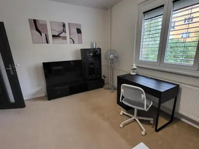 a room with a desk and a chair and a television at Fox Den Prague in Prague