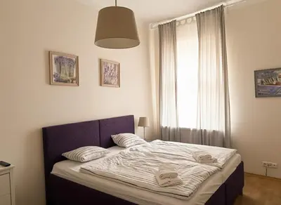 a bedroom with a bed with a blue headboard and a window at Petrska Cozy 2 bedroom apartment near Old Town in Prague