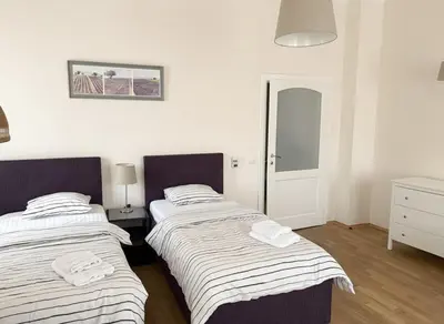 two beds in a room with white walls at Petrska Cozy 2 bedroom apartment near Old Town in Prague