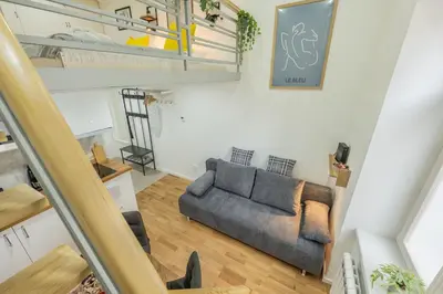 a living room with a couch and a staircase at HOMELY I Central 28m2 loft I ELEVATOR I Self Check-In in Prague