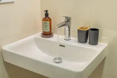 a sink with a bottle and cups on it at HOMELY I Central 28m2 loft I ELEVATOR I Self Check-In in Prague