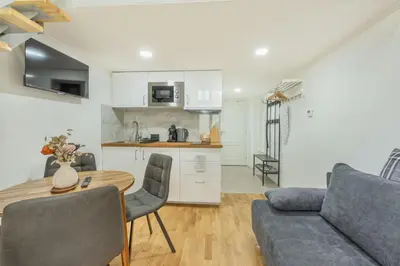 a kitchen and living room with a table and a couch at HOMELY I Central 28m2 loft I ELEVATOR I Self Check-In in Prague