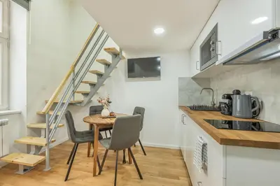 a kitchen with a table and chairs and a staircase at HOMELY I Central 28m2 loft I ELEVATOR I Self Check-In in Prague