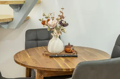 a vase with flowers on a wooden table at HOMELY I Central 28m2 loft I ELEVATOR I Self Check-In in Prague