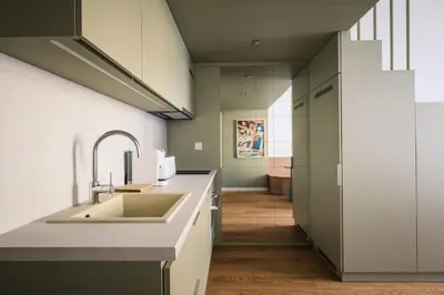 a kitchen with white counters and a sink at Modern design studio with fast WI-FI in Prague