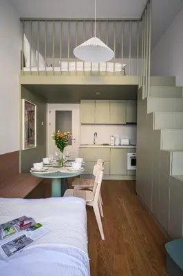 a room with a bed and a table and a kitchen at Modern design studio with fast WI-FI in Prague