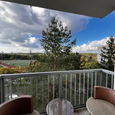 a balcony with chairs and a view of a baseball game at Apartment in Prague in a quiet location close to the center in Prague