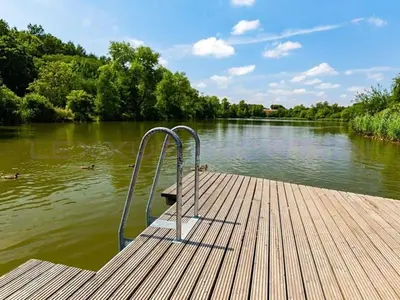 a bench on the end of a dock on a river at Prague house in Green Oasis 10min to the downtown in Prague