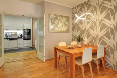 a dining room with a wooden table and white chairs at Modern & Elegance Suite Apartment Prague in Prague