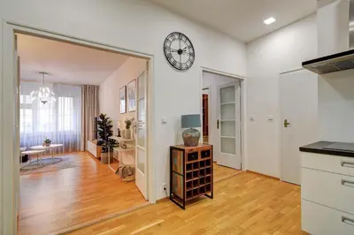 a kitchen and living room with a clock on the wall at Modern & Elegance Suite Apartment Prague in Prague