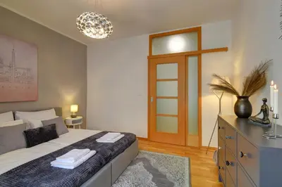 a bedroom with a bed and a dresser with towels on it at Modern & Elegance Suite Apartment Prague in Prague