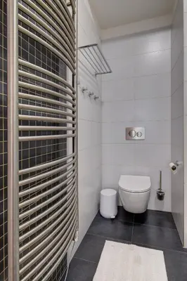 a white bathroom with a toilet and a window at Modern & Elegance Suite Apartment Prague in Prague