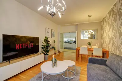 a living room with a couch and a tv and a table at Modern & Elegance Suite Apartment Prague in Prague